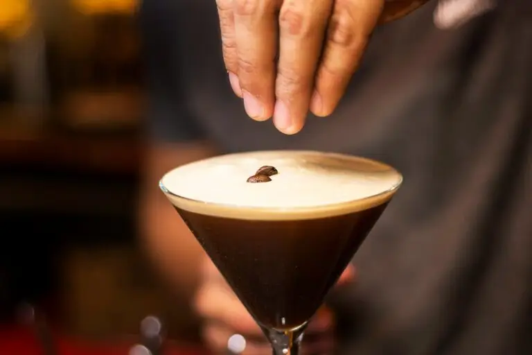 Espresso Martini Glas Finger und Kaffeebohnen